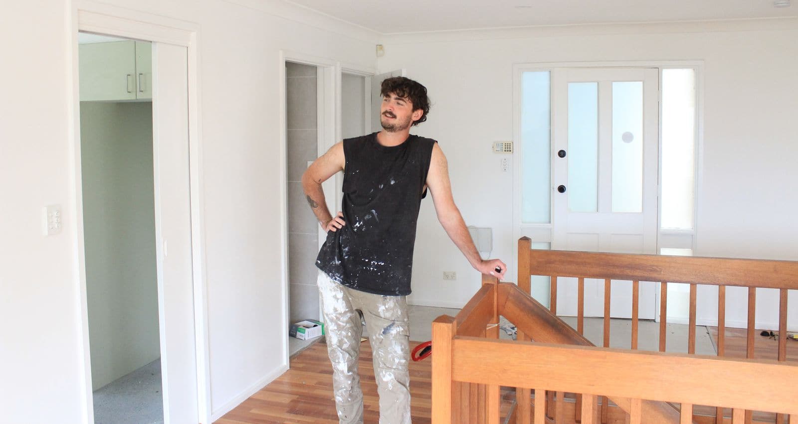 Dylan on a job in an open living area beside a timber staircase